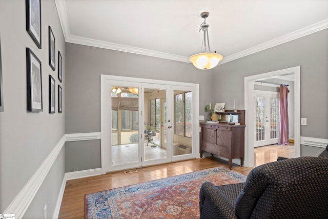 interior space with french doors, a healthy amount of sunlight, crown molding, and hardwood / wood-style floors