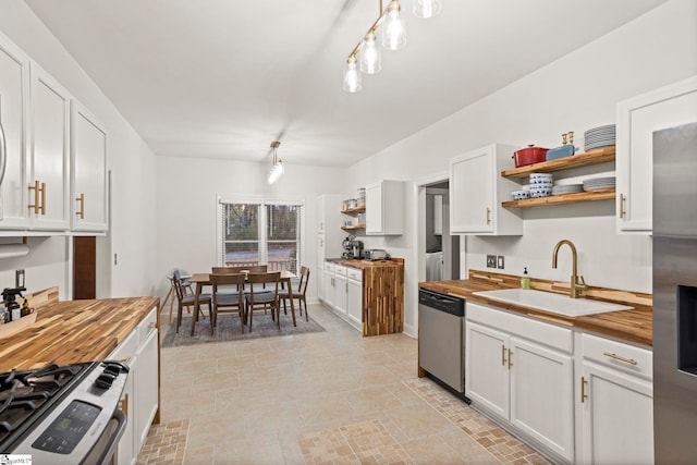 kitchen featuring stainless steel appliances, butcher block counters, and sink