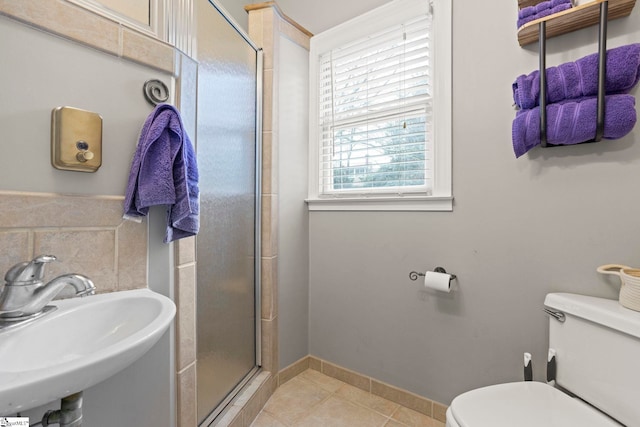 bathroom with an enclosed shower, sink, tile patterned floors, and toilet