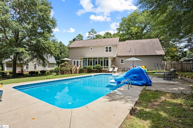 view of swimming pool with a water slide and a patio area