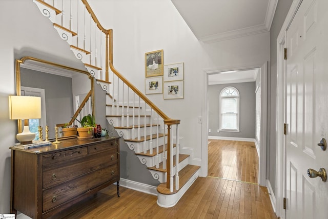 entryway with ornamental molding and light hardwood / wood-style floors