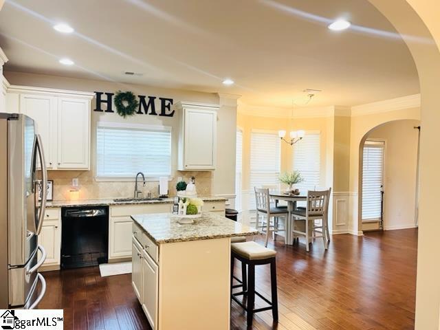 kitchen with black dishwasher, white cabinetry, a kitchen island, and dark hardwood / wood-style floors