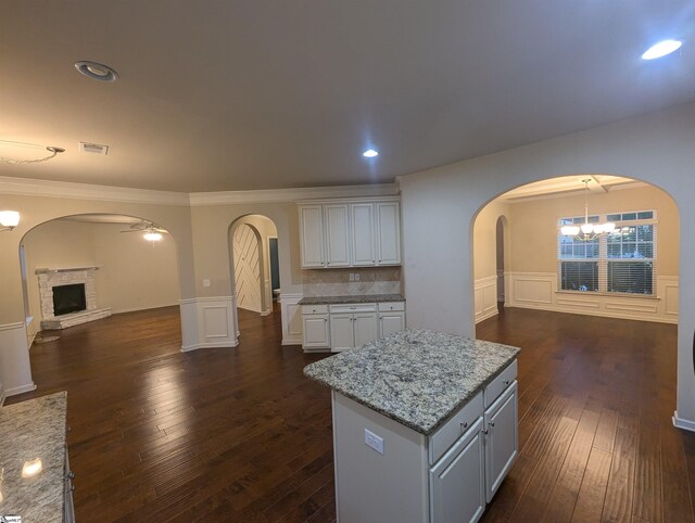 kitchen featuring dark wood-type flooring, black appliances, a center island, and sink