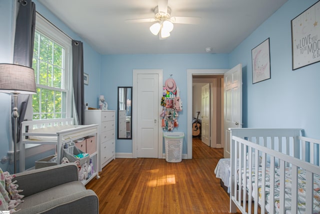 bedroom with dark hardwood / wood-style floors and ceiling fan