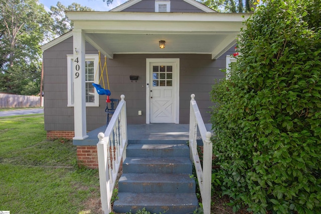 entrance to property featuring a lawn