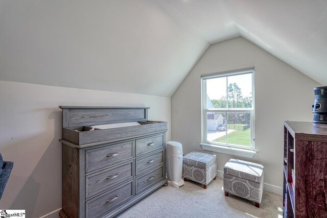 bedroom with vaulted ceiling and light colored carpet