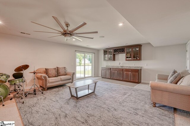 carpeted living room featuring sink and ceiling fan