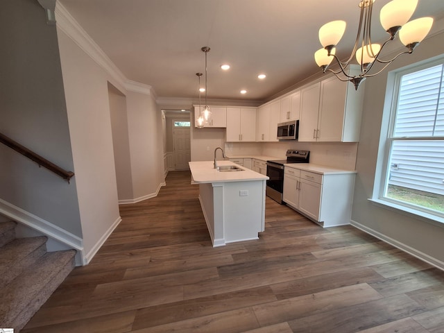 kitchen with an island with sink, appliances with stainless steel finishes, sink, and white cabinetry