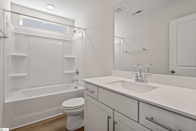 full bathroom with hardwood / wood-style flooring, shower / bathtub combination, vanity, and toilet