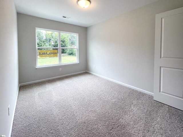 unfurnished room featuring visible vents, baseboards, and carpet