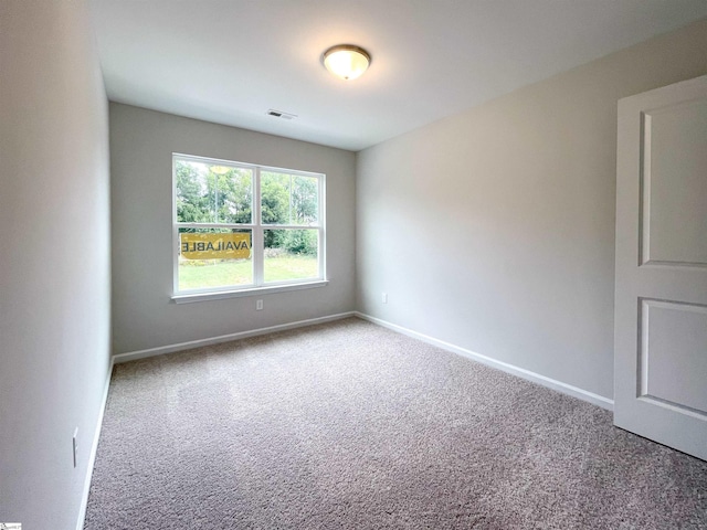 carpeted empty room with visible vents and baseboards