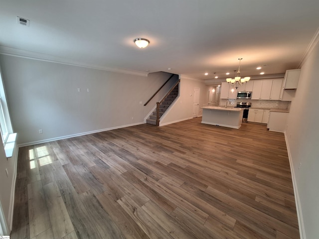 unfurnished living room with crown molding, sink, an inviting chandelier, and dark hardwood / wood-style flooring