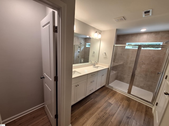 bathroom with vanity, a shower with shower door, and hardwood / wood-style flooring