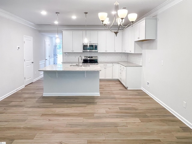 kitchen featuring light wood-style flooring, stainless steel appliances, white cabinetry, crown molding, and tasteful backsplash