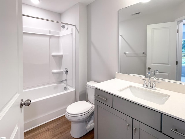 full bathroom featuring wood-type flooring, shower / tub combination, vanity, and toilet