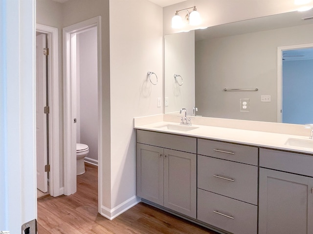 bathroom with hardwood / wood-style floors, vanity, and toilet