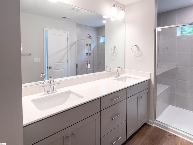 bathroom featuring hardwood / wood-style floors, an enclosed shower, and vanity