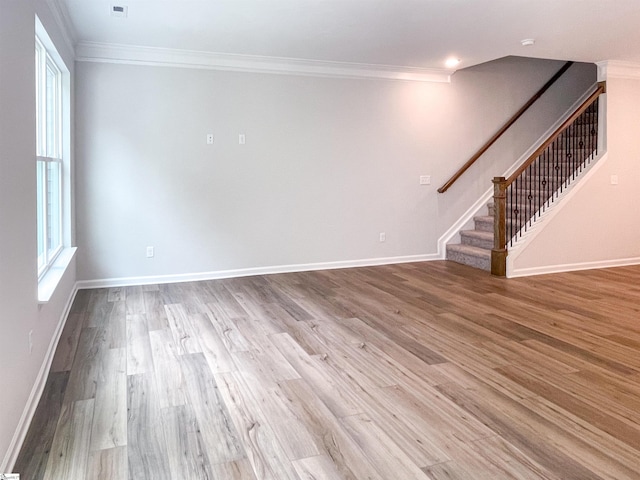 unfurnished living room featuring stairway, wood finished floors, baseboards, and ornamental molding