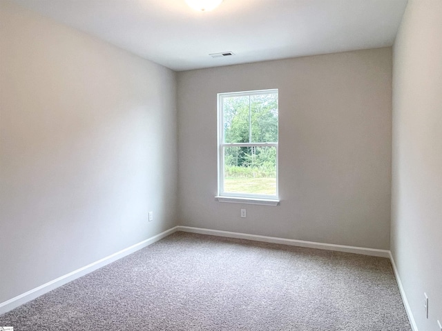 unfurnished room featuring visible vents, carpet, and baseboards