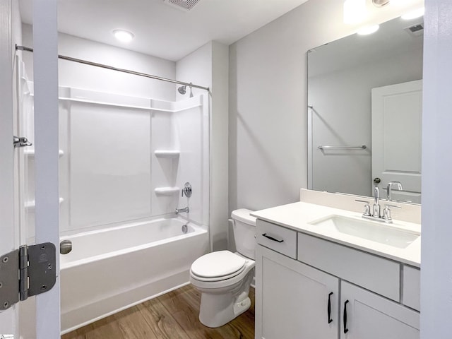 bathroom with visible vents, toilet, wood finished floors, tub / shower combination, and vanity