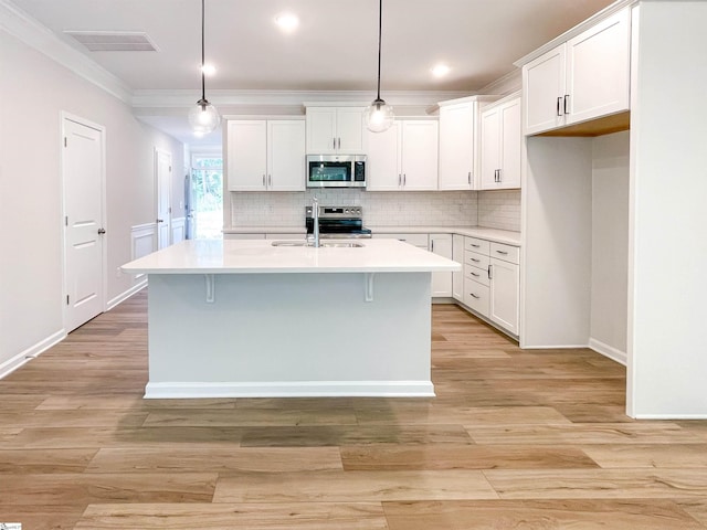 kitchen with a sink, stainless steel appliances, white cabinets, and light countertops