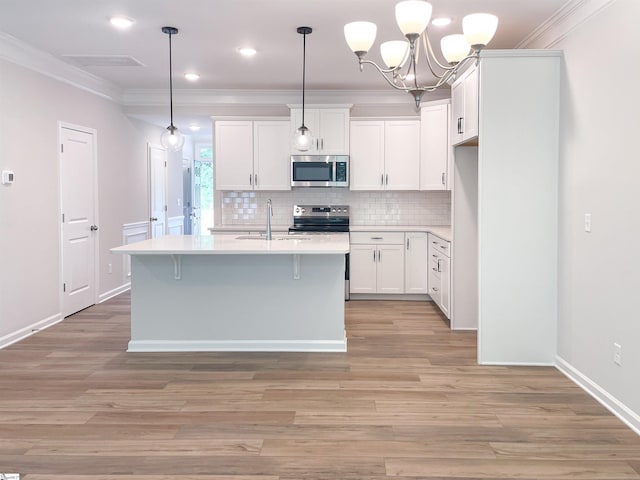 kitchen with crown molding, light countertops, decorative backsplash, light wood-style floors, and stainless steel appliances