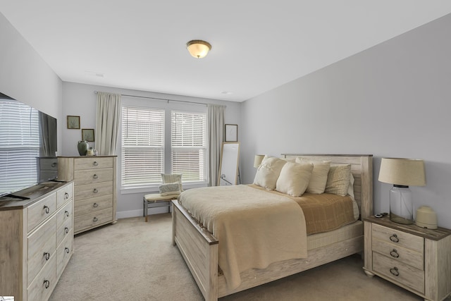 bedroom with light colored carpet and baseboards