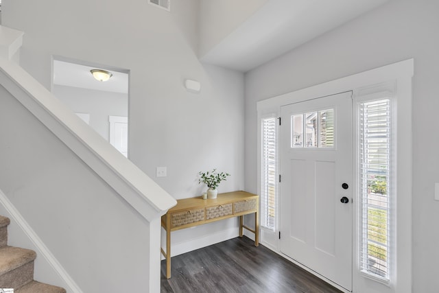 foyer featuring visible vents, dark wood finished floors, baseboards, and stairs