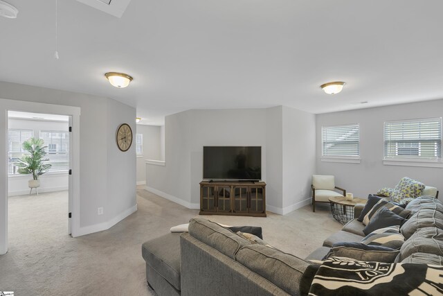 living room with a wealth of natural light and light colored carpet