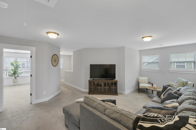 living room featuring light carpet, attic access, and baseboards