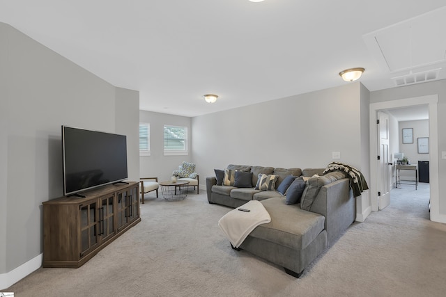 living room featuring baseboards, visible vents, attic access, and light colored carpet