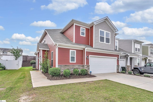 view of front of home with a garage, driveway, stone siding, fence, and a front yard