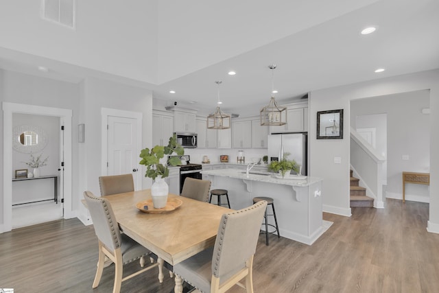 dining room with recessed lighting, visible vents, stairway, and light wood finished floors