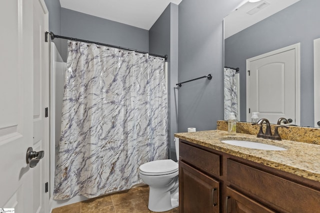 bathroom featuring tile patterned flooring, toilet, and vanity