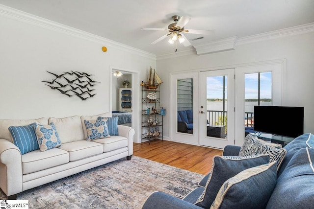 living room with crown molding, ceiling fan, and wood-type flooring