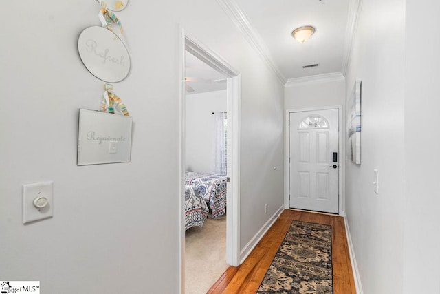 hallway with wood-type flooring and ornamental molding