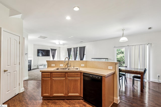 kitchen with dishwasher, light countertops, open floor plan, and a sink