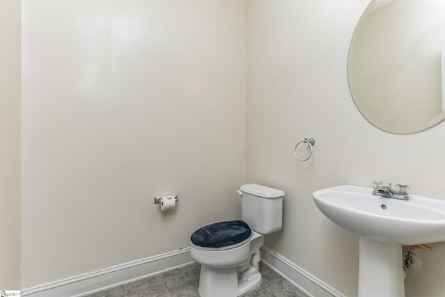 bathroom featuring toilet, baseboards, and tile patterned floors