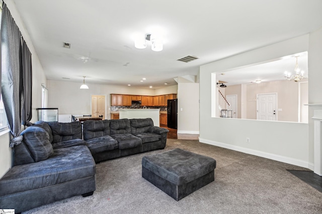 living room with stairs, dark carpet, visible vents, and baseboards