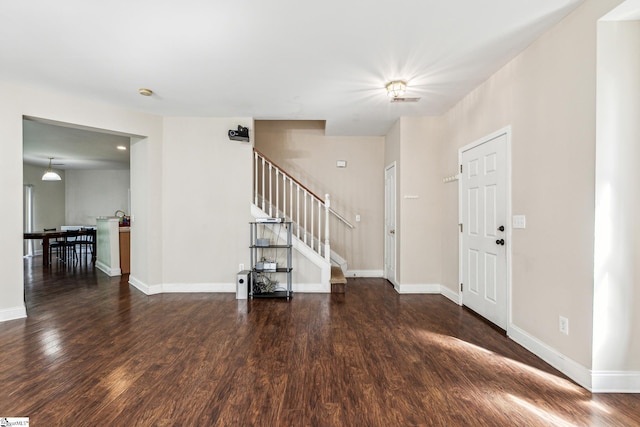 foyer with baseboards, stairway, and wood finished floors