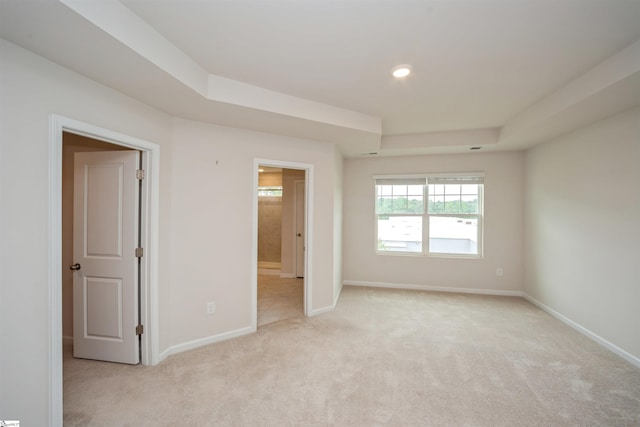 carpeted empty room featuring a raised ceiling