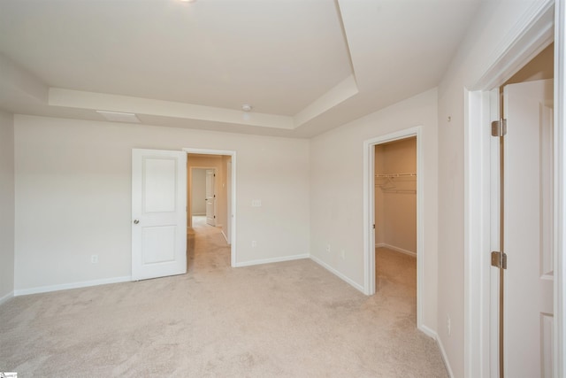 carpeted spare room featuring a tray ceiling