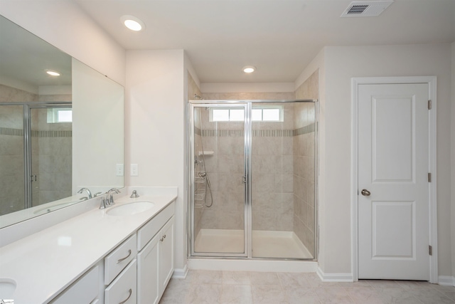 bathroom with vanity, a shower with door, and tile patterned flooring