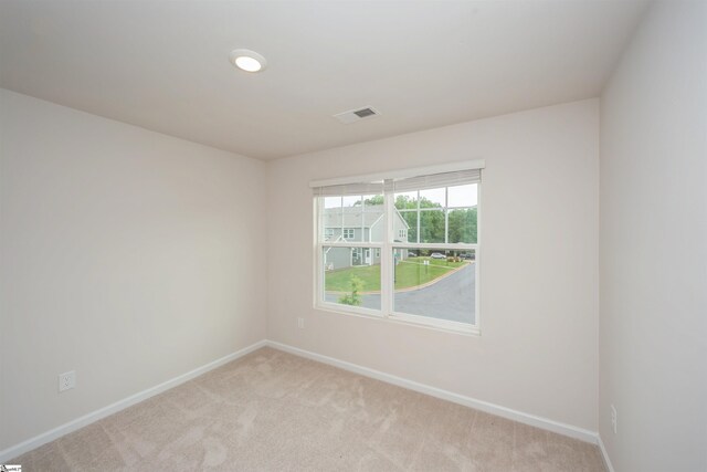 spare room featuring light colored carpet