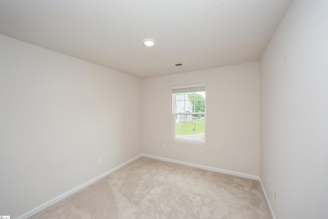 spare room featuring light colored carpet