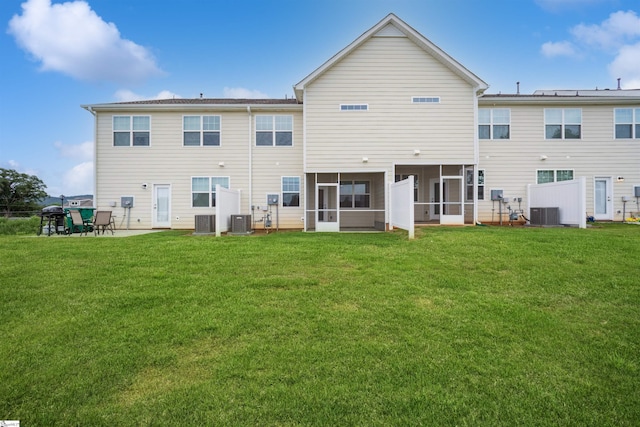 back of property with a lawn, a sunroom, and cooling unit