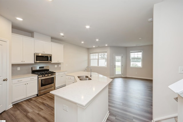 kitchen featuring appliances with stainless steel finishes, sink, light hardwood / wood-style flooring, and backsplash