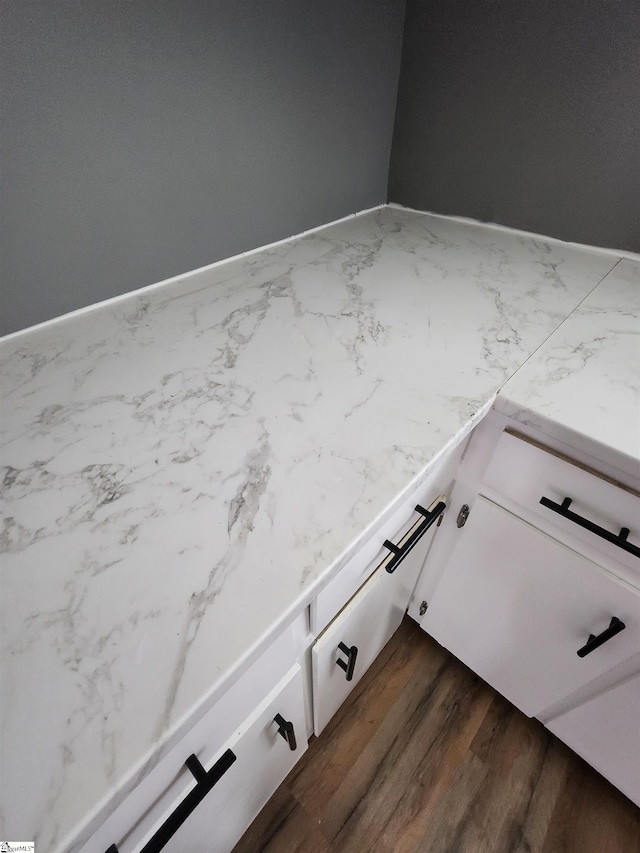 details with dark wood-style floors, light countertops, and white cabinets