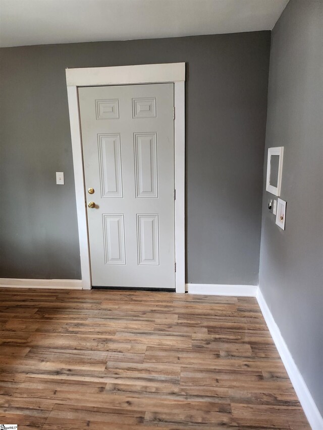 unfurnished room featuring baseboards and wood finished floors