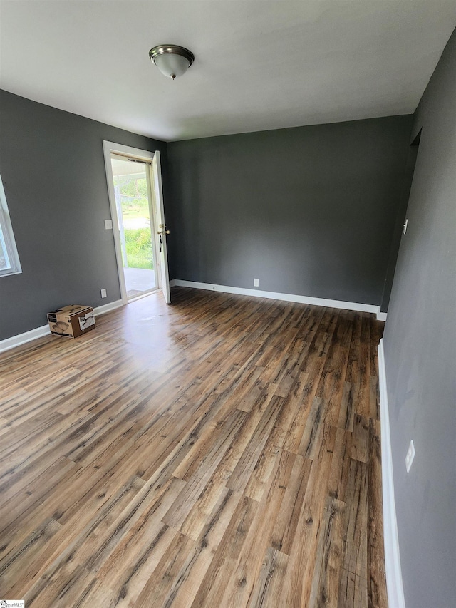 empty room with baseboards and wood finished floors